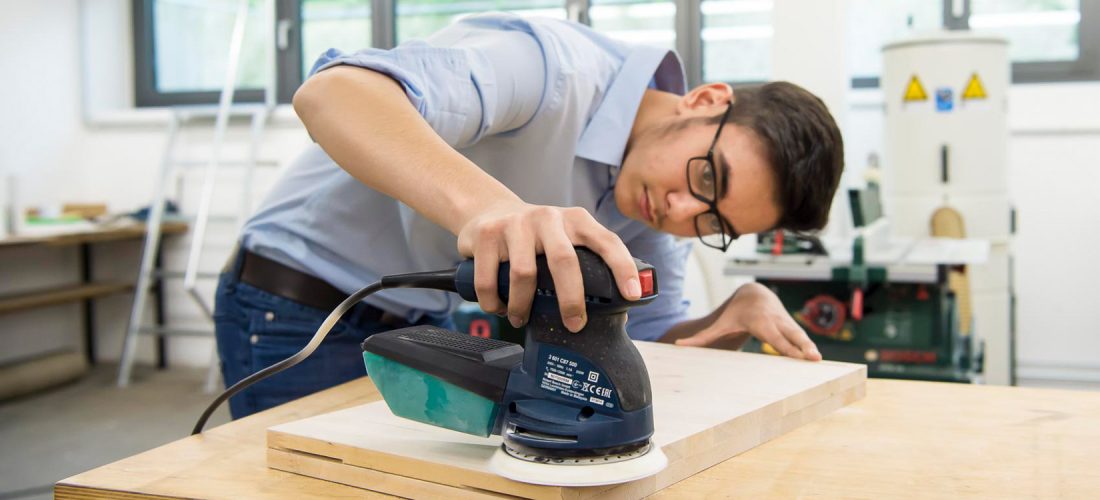 Schüler arbeitet mit einer Schleifmaschine